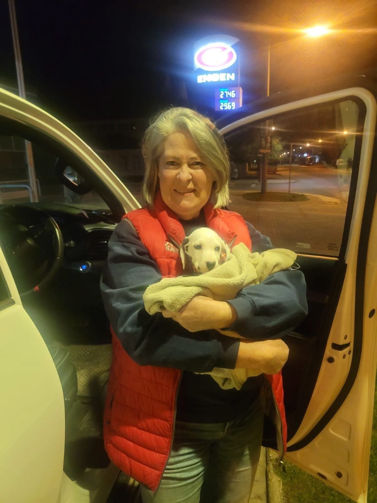 A handover after dark at a filling station, puppy wrapped and warm