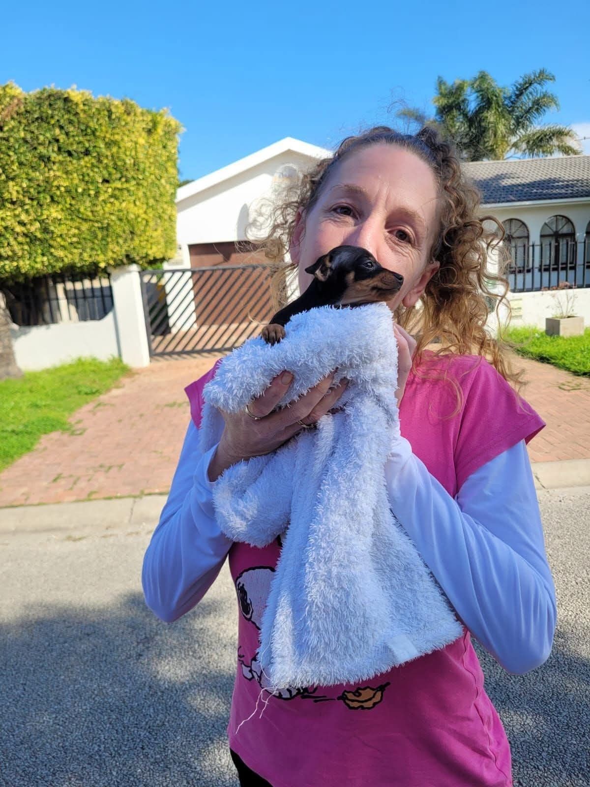 A girl wrapping her new puppy in a towel moments after arrival
