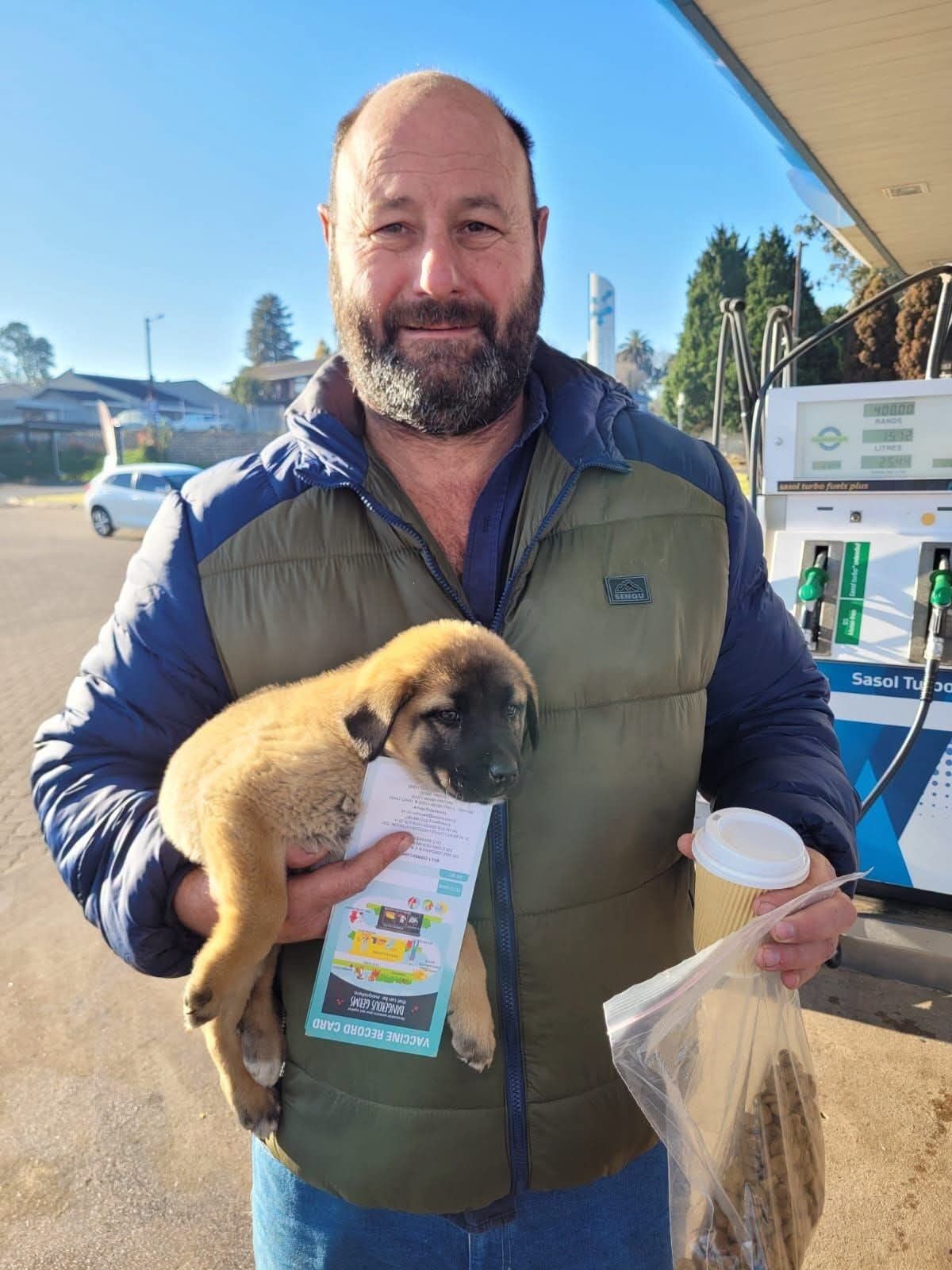 A puppy handed over at a filling station, paperwork travelling with her
