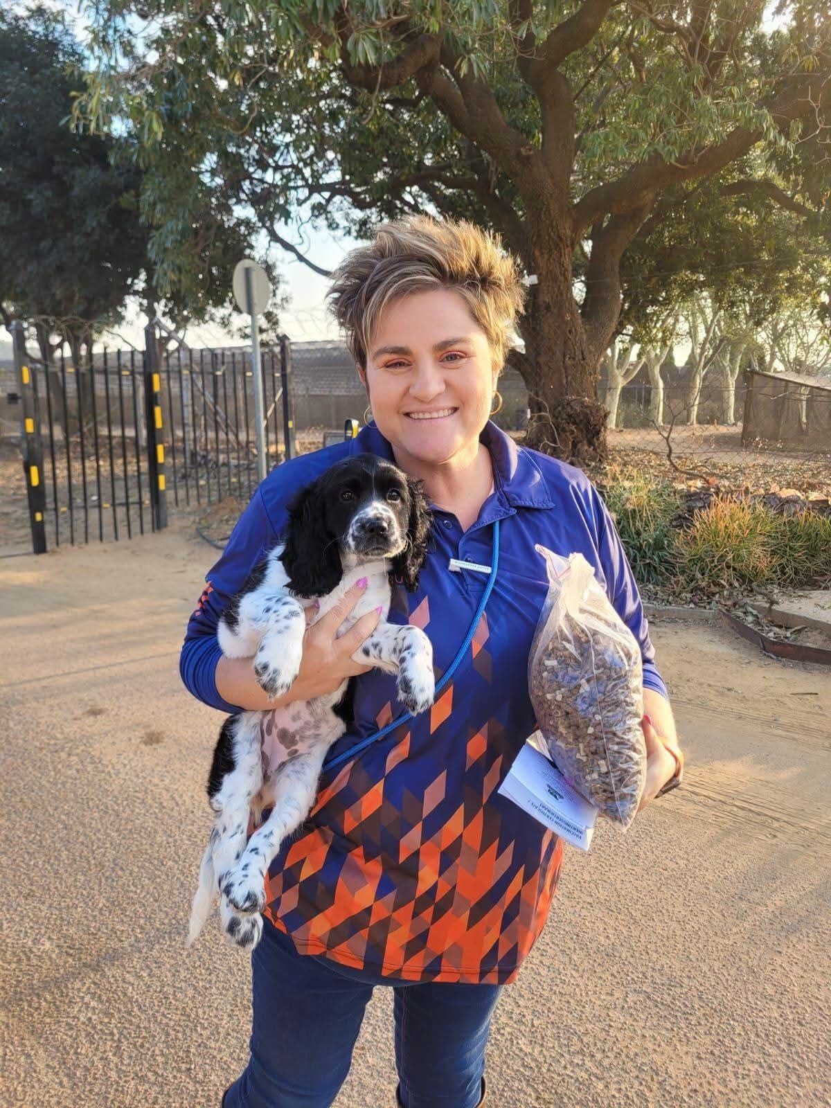 A new owner with her spaniel puppy on the driveway