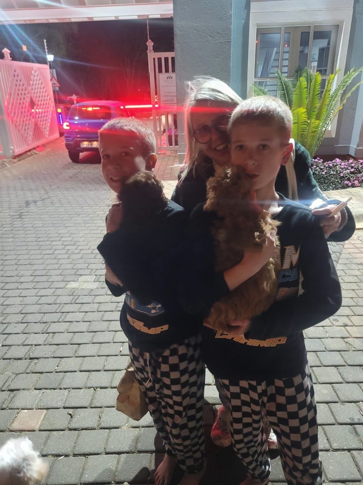 Two young people collecting their dogs at night