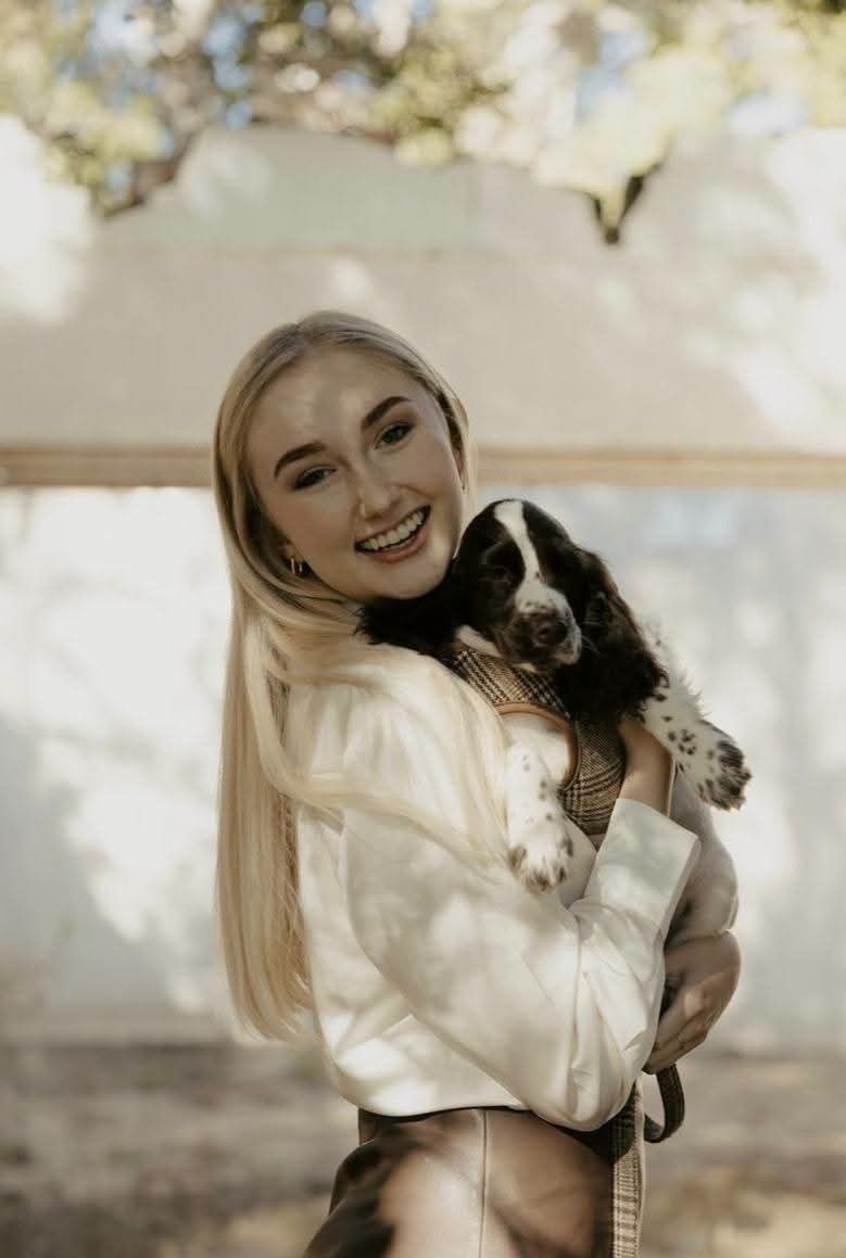 A young woman outdoors with her spaniel puppy