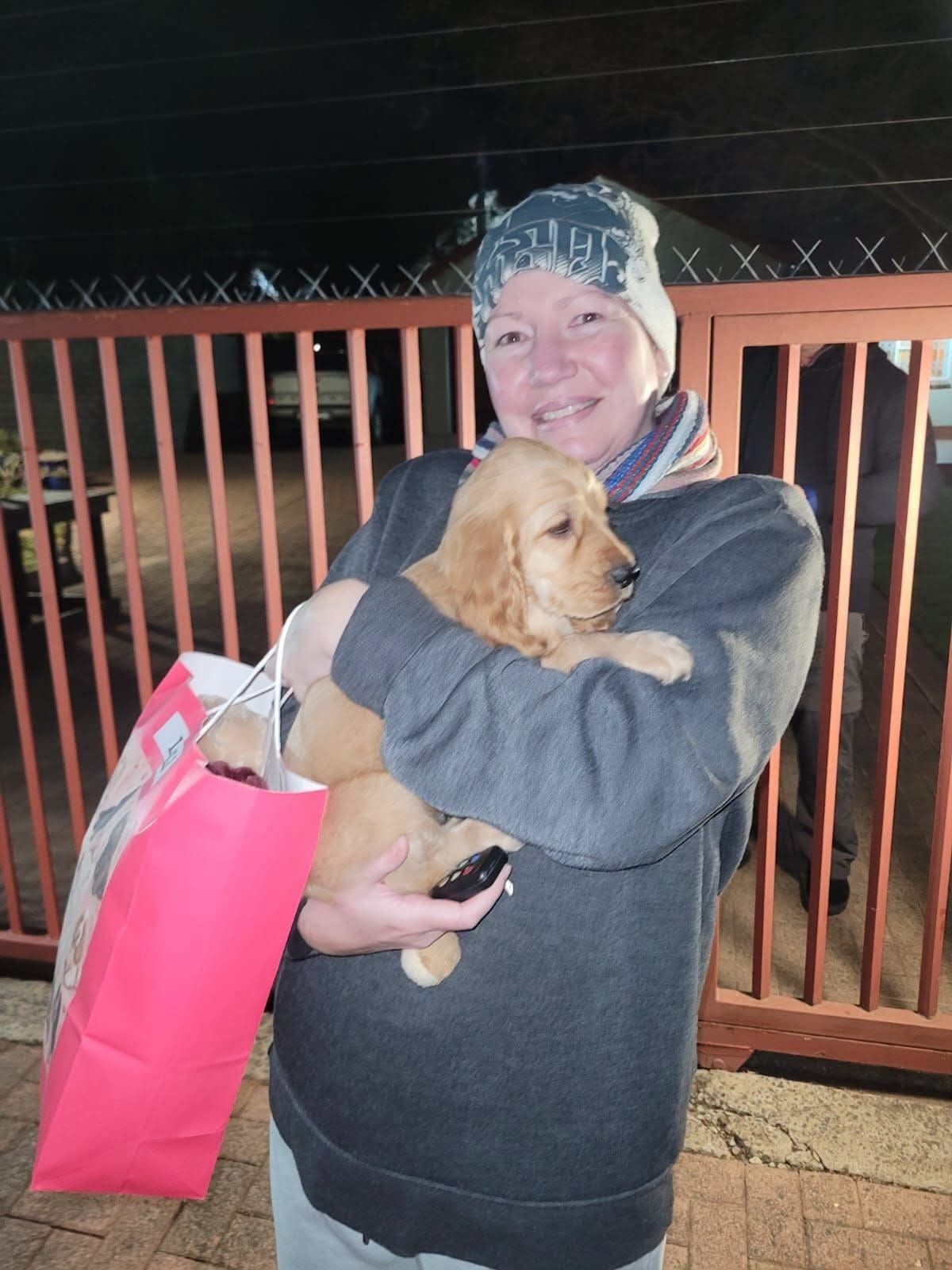 A puppy carried in a sling bag with the breeder's gifts