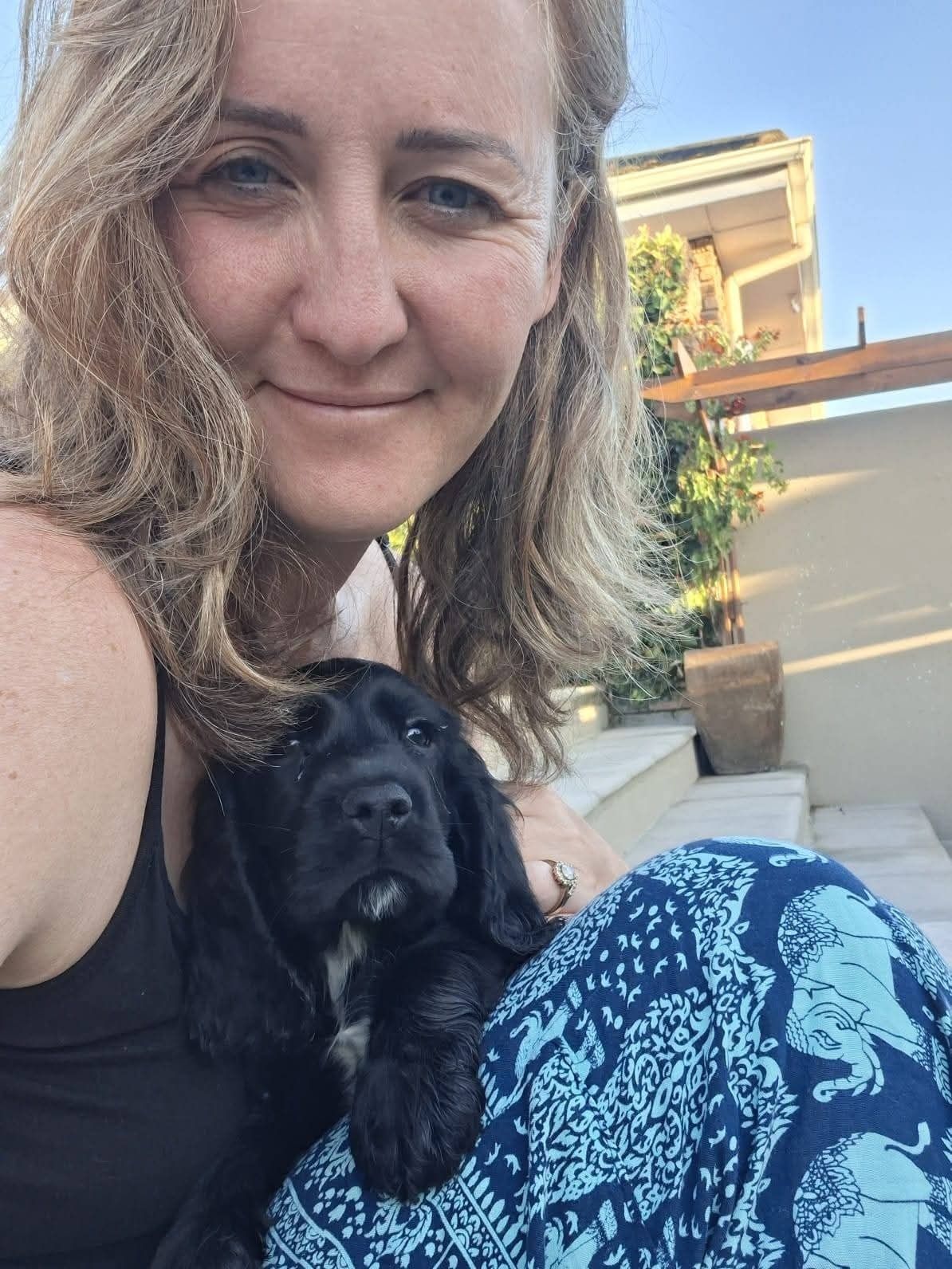 A new owner and her black spaniel puppy, first day home